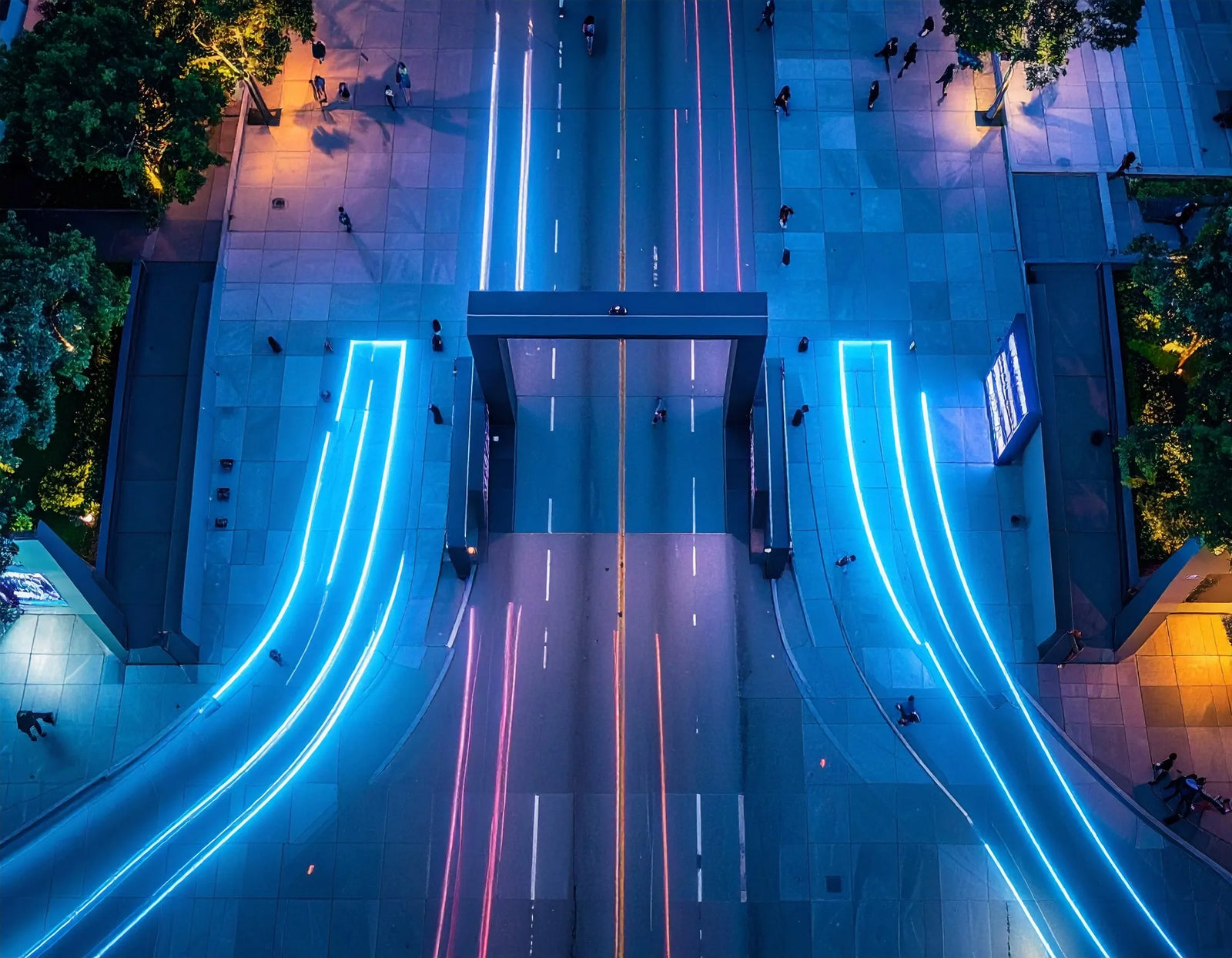 Aerial view of a modern urban plaza at night with glowing LED light strips along walkways.