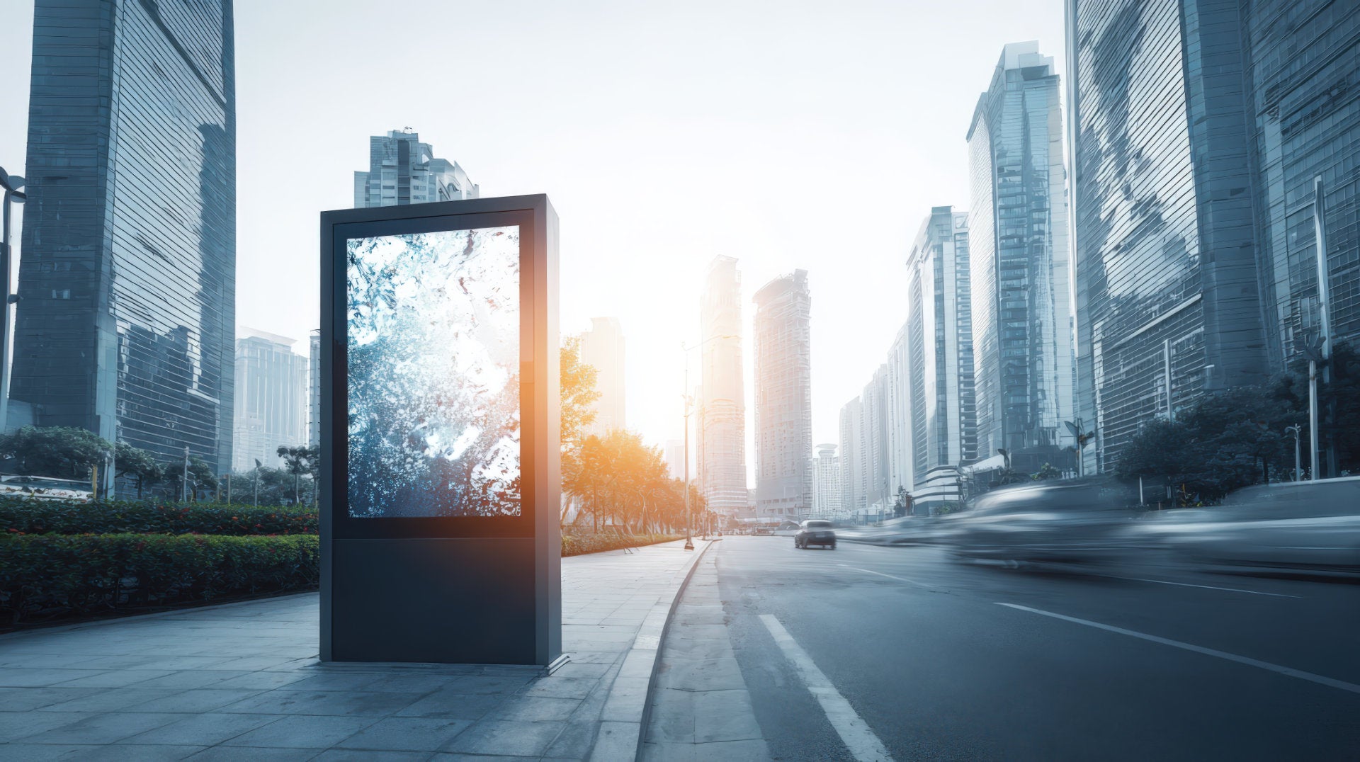 Digital billboard display along a city street lined with modern buildings.